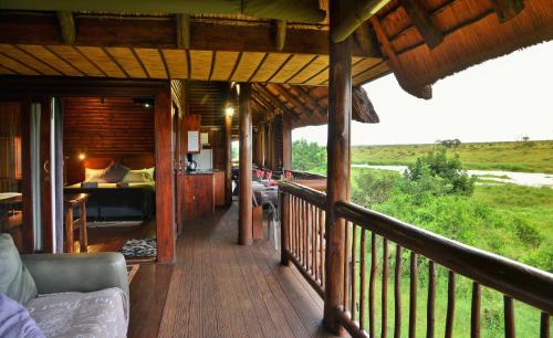 a porch of a house with a bedroom and a bed at Elephant Walk Retreat in Komatipoort