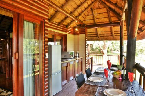 a kitchen with a wooden table and a refrigerator at Elephant Walk Retreat in Komatipoort