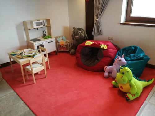 a room with two stuffed animals sitting on a red rug at Penzión Uhliská a Depandance Gazdovský dom in Nemšová