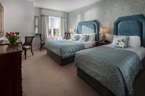 a hotel room with two beds and a table and chairs at The Landmark Hotel in Carrick on Shannon