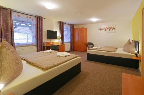 a hotel room with two beds and a television at Landhotel & Brauhaus Prignitzer Hof in Pritzwalk