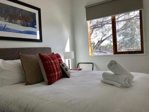 a bedroom with a white bed with a window at Apres in Dinner Plain