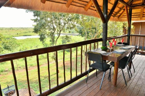 a wooden deck with a table and chairs on it at Elephant Walk Retreat in Komatipoort