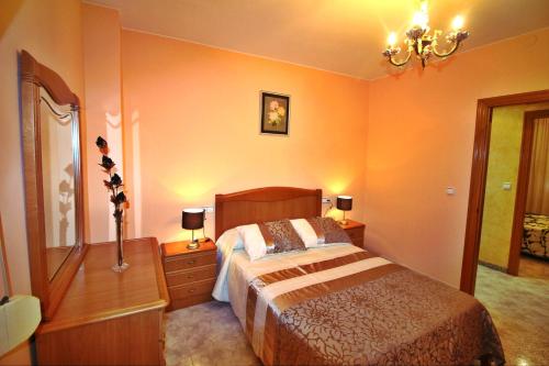 Schlafzimmer mit einem Bett und einem Kronleuchter in der Unterkunft Casa Razo da Costa in Razo da Costa