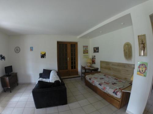 a living room with a bed and a chair at gîte en sud Ardèche in Ruoms