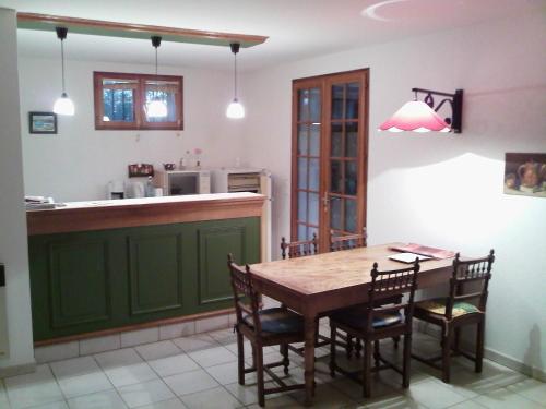 ルオムにあるgîte en sud Ardècheのキッチン(木製テーブル、椅子付)