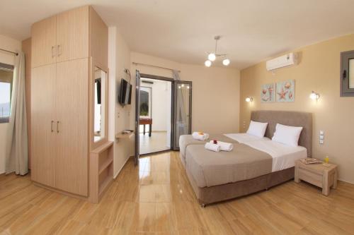 a bedroom with a large bed and a sliding glass door at Kefalonia Horizon Villas in Ayia Evfimia