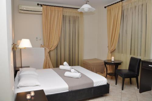 ein Hotelzimmer mit einem Bett und einem Stuhl in der Unterkunft Al Mare in Asprovalta
