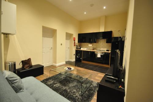 a living room with a couch and a kitchen at Luxurious 2 Bed Apartment in Bedford