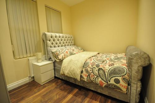 a bedroom with a bed and a chair in it at Luxurious 2 Bed Apartment in Bedford
