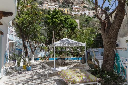 a gazebo and chairs on a patio with a tree at Positano Suite in Positano