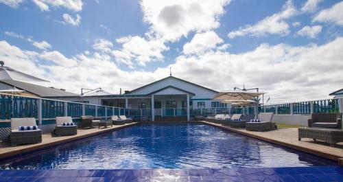 a swimming pool with lounge chairs and a building at Tete Ferry Sun in Vila-de-Santiago-Maior