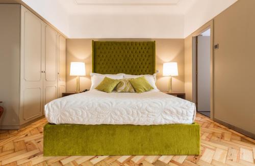 a bedroom with a large bed with a green headboard at Hotel Porto Mar in Matosinhos