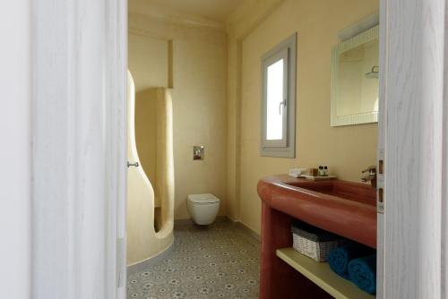 a bathroom with a toilet and a sink at Ikies Santo Filoxenia Apartments in Karterados