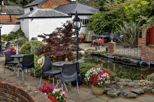 a garden with a table and chairs next to a pond at Best Western Annesley House Hotel in Norwich