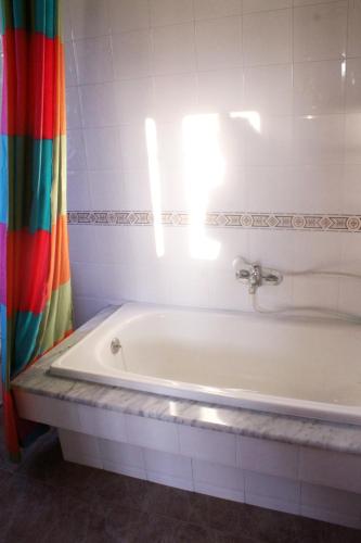 a bath tub in a bathroom with a shower curtain at Casa rural agro da moa in As Mirans