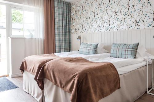 a bedroom with a large bed in a room at Katrinelund Gästgiveri & Sjökrog in Stora Mellösa