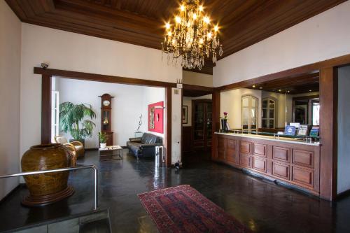 a large living room with a chandelier and a lobby at Vitória Palace Hotel in Lavras