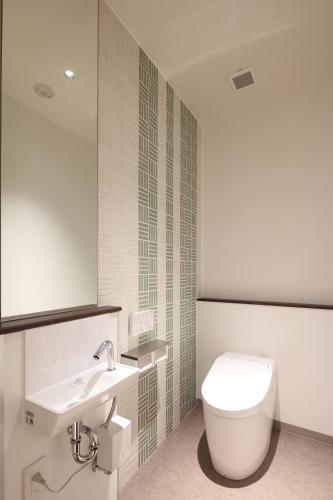 a bathroom with a toilet and a sink at New Matto Terminal Hotel in Hakusan