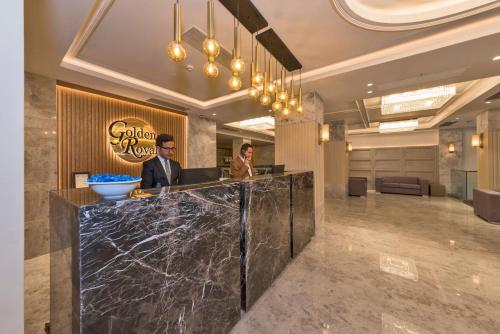 a man standing at a counter in a lobby at Golden Royal Hotel & SPA in Istanbul