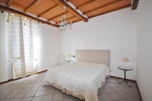 a bedroom with a white bed and a wooden ceiling at Villino Michela in Marina di Pietrasanta