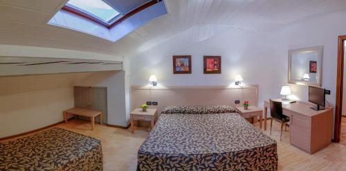 a hotel room with two beds and a skylight at Hotel Monte Cimone in Caldonazzo