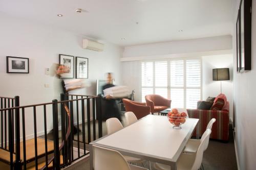 a living room with a white table and chairs at Alto Hotel On Bourke in Melbourne