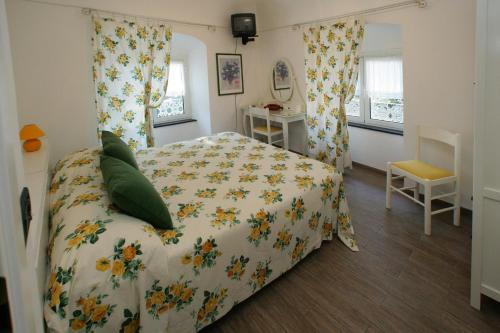 a bedroom with a bed with a floral bedspread at Hotel Sereno in Cogoleto