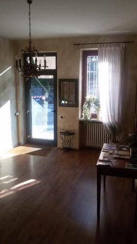 a living room with a wooden floor and a chandelier at La Rocchetta in Valeggio sul Mincio
