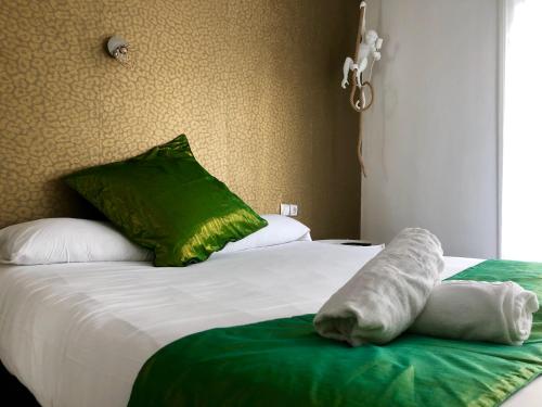 a bed with a white comforter and pillows on it at Sitges Eleven in Sitges