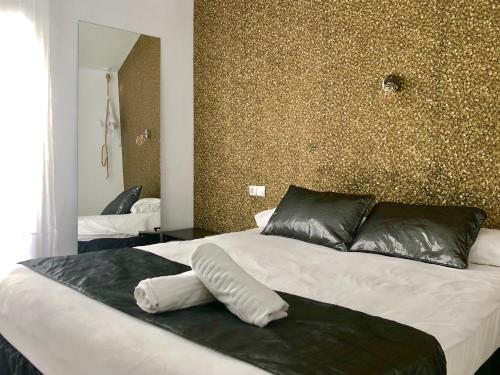 a bedroom with a large bed with black and white pillows at Sitges Eleven in Sitges