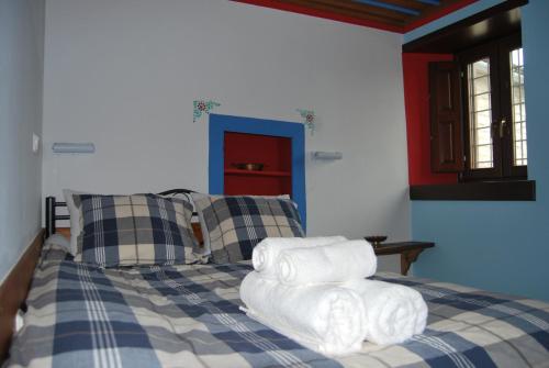 a bedroom with a bed with towels on it at Tritoxo Guesthouse in Koukouli