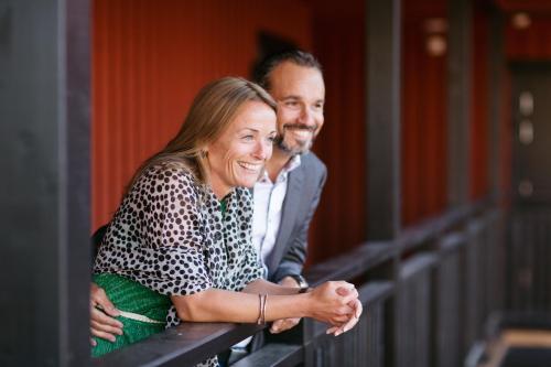 a man and a woman looking over a railing at Katrinelund Gästgiveri & Sjökrog in Stora Mellösa