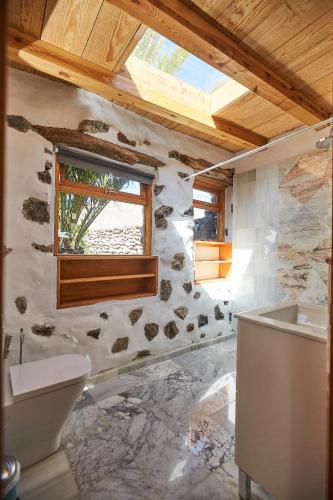 a bathroom with a toilet and a sink and a window at Villa Palmeras Canarias in Uga
