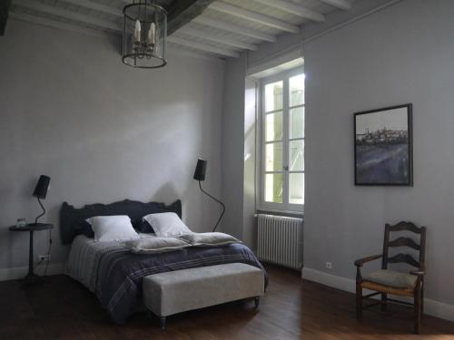 a bedroom with a bed and a chair and a window at DOMAINE D'ENTUDELLE in Lussan