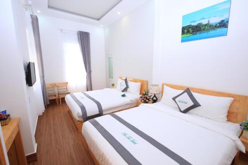 a hotel room with two beds and a television at Moc Tra Hotel in Da Lat