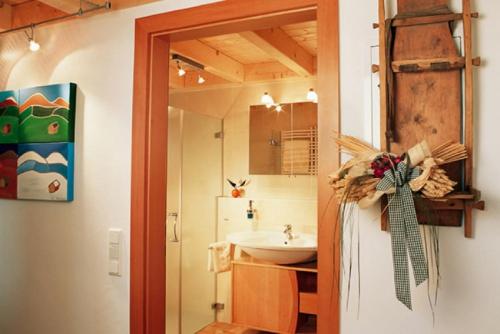 a bathroom with a sink and a mirror and a refrigerator at Ferienwohnung Anderl in Obertauern