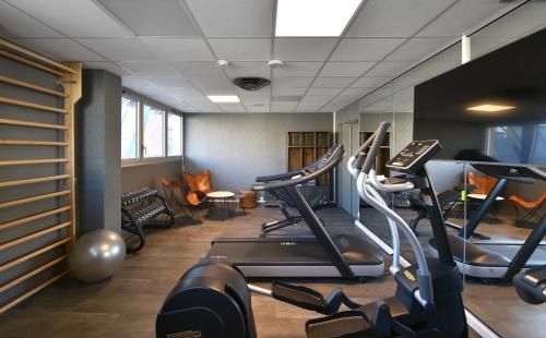a gym with treadmills and ellipticals in a room at Mercure Le Havre Centre Bassin Du Commerce in Le Havre