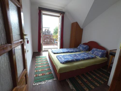 a small bedroom with a bed and a window at Barátság Ház in Alsóörs