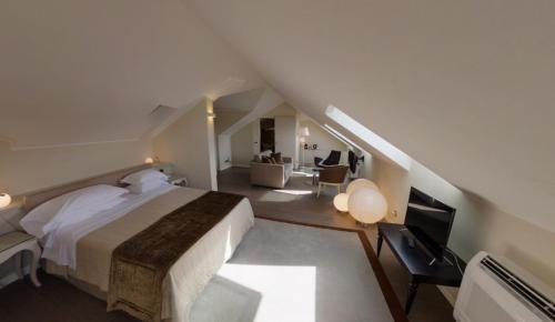 a large white bedroom with a bed and a living room at Hotel Miramare & Spa in Sestri Levante