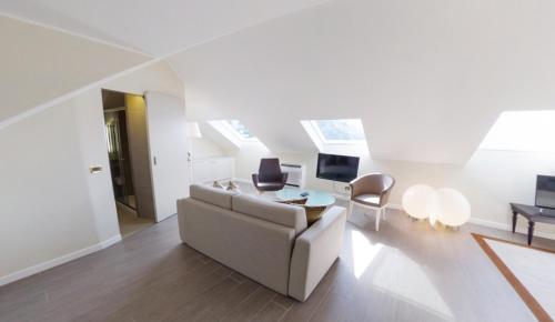 a white living room with a couch and a tv at Hotel Miramare & Spa in Sestri Levante