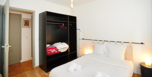 a bedroom with a white bed with a black cabinet at Appart' Maréchal in Lyon