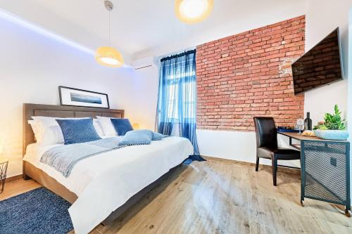 a bedroom with a brick wall and a bed and a desk at INFINITY CENTAR Zagreb in Zagreb