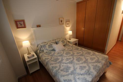 カンブリルスにあるApartamento Blau Maríの小さなベッドルーム(ベッド1台、ナイトスタンド2台付)