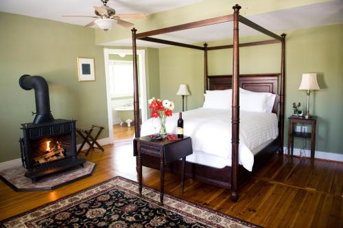 1 dormitorio con cama con dosel y estufa de leña en Hopkins Ordinary Bed, Breakfast and Ale Works, en Sperryville