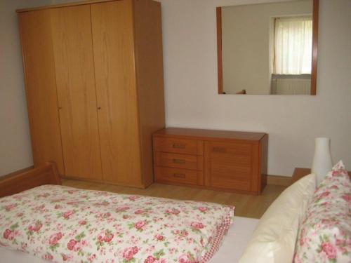 a bedroom with a bed and a dresser and a mirror at Haus Gartentraum in Sommerhausen