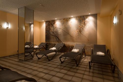 a waiting room with chairs and a painting on the wall at Alpenland St Johann in Sankt Johann im Pongau