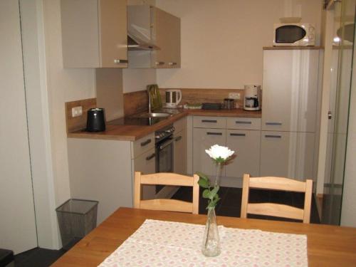 a kitchen with a table and a vase with a flower in it at Haus Gartentraum in Sommerhausen