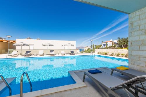 a large swimming pool with chairs at Sun and Sea Plus Resort in Plaka