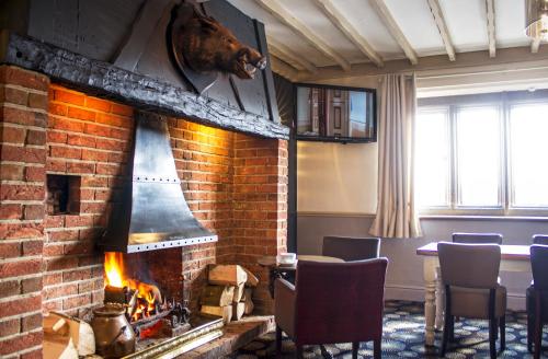 a room with a fireplace with a horse head on the wall at The Boars Head Hotel in Sudbury